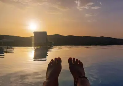 a person laying in a body of water with their feet in the water at Kasbah Zitoune in Ouarzazate