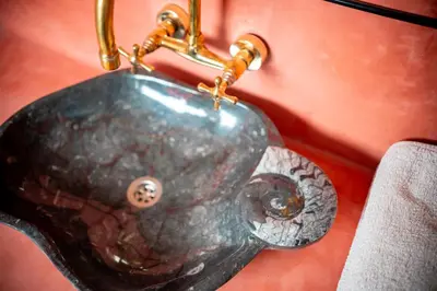 a sink with an elephant head on a red wall at Kasbah Zitoune in Ouarzazate