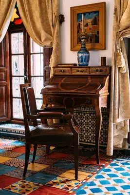 a chair in front of a piano in a room at La Maison Bleue Batha in Fès