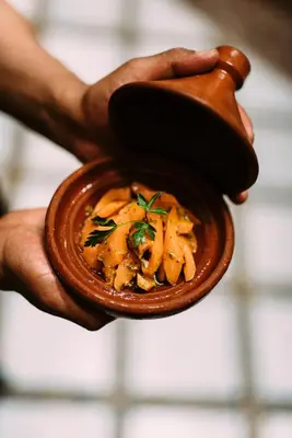 a person holding a small bowl of food at La Maison Bleue Batha in Fès