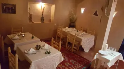 a dining room with tables and chairs with white table cloth at Dar Bilal in Aït Ben Haddou