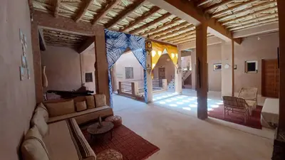 a living room with a couch and a room with a table at Dar Bilal in Aït Ben Haddou