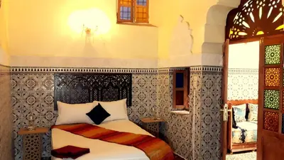 a bedroom with a bed with a black and white headboard at Dar nadaa in Fès