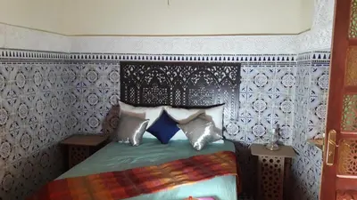 a bedroom with a bed with blue and white wallpaper at Dar nadaa in Fès