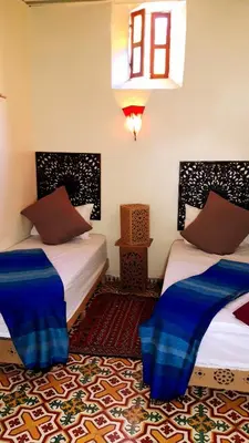 a room with two beds and a window at Dar nadaa in Fès