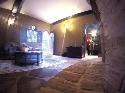 a living room with a table and a stone wall at La Rose Du Desert in Erfoud
