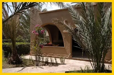 a building with a arch with flowers in it at La Rose Du Desert in Erfoud