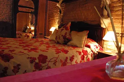 a bedroom with a bed with red flowers on it at La Rose Du Desert in Erfoud