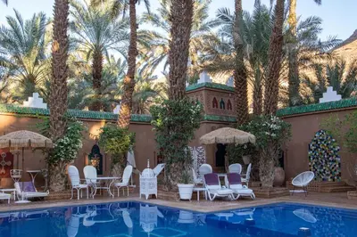 a resort with palm trees and a swimming pool at Riad Dar Sofian in Zagora