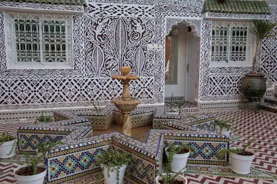 a fountain in the middle of a courtyard with potted plants at Riad Dar Sofian in Zagora