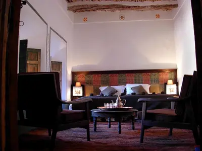 a bedroom with a bed and a table and chairs at Kasbah Tigmi N'Oufella in Telouet