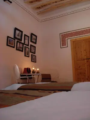 a bedroom with two beds and a table with candles at Kasbah Tigmi N'Oufella in Telouet