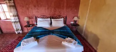 a bedroom with a bed with a metal headboard at Chez Laila in Skoura