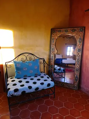 a bedroom with a bed and a mirror at Chez Laila in Skoura