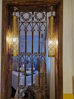 a mirror with a gate with a table in a room at Dar Rihana Dadès in Aït Idaïr