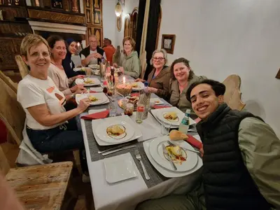 a group of people sitting around a table eating food at Dar Rihana Dadès in Aït Idaïr