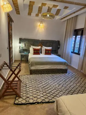 a bedroom with two beds and a rug in a room at Dar Rihana Dadès in Aït Idaïr