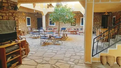 a patio with a table and chairs and a table and chairs at Kasbah Imini Restaurant & Hotel in Taourirt