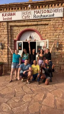 a group of people posing in front of a building at Kasbah Imini Restaurant & Hotel in Taourirt