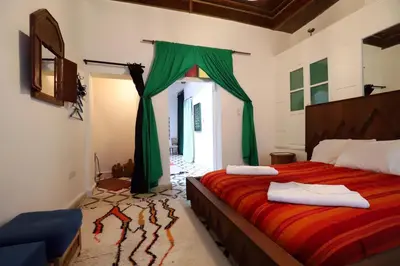 a bedroom with a bed with green drapes at Dar Zerhoune in Moulay Idriss Zerhoun