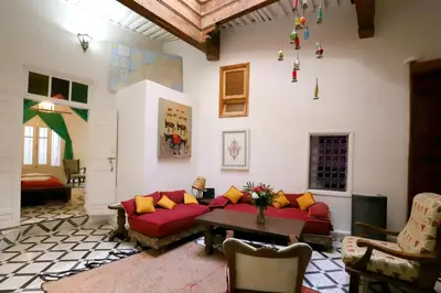 a living room with a red couch and a table at Dar Zerhoune in Moulay Idriss Zerhoun