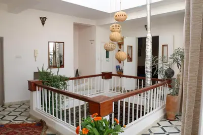 a foyer with white walls and a staircase with wooden railings at Dar Zerhoune in Moulay Idriss Zerhoun