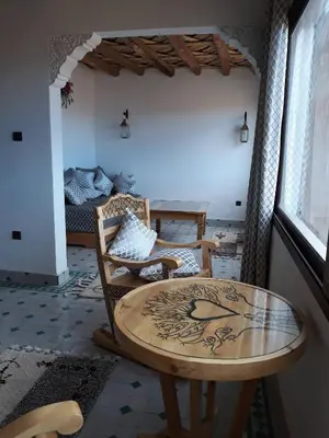 a living room with a table and a couch at Taloute Ecolodge in Skoura