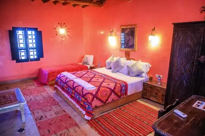 a bedroom with a large bed in a red room at Taloute Ecolodge in Skoura