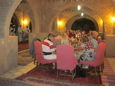 a group of people sitting at a table in a room at Haven La Chance Desert Hotel in Merzouga
