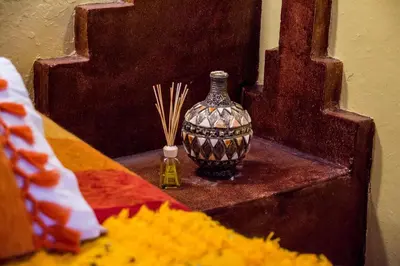 a vase sitting on a table next to a mirror at Haven La Chance Desert Hotel in Merzouga
