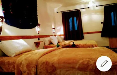 a hotel room with two beds in a bedroom at Riad pizzeria Marhaba in Akhendachou nʼAït Ouffi