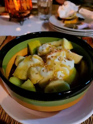 a bowl of food sitting on a table with vegetables at Riad pizzeria Marhaba in Akhendachou nʼAït Ouffi