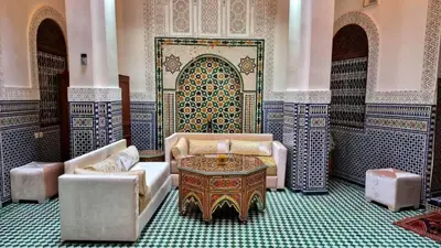 a room with a table and chairs and a mosaic door at Dar La Bague de Kenza in Fès