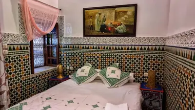 a bedroom with a bed and a painting on the wall at Dar La Bague de Kenza in Fès