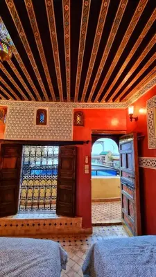 a bedroom with red walls and a ceiling with a window at Dar La Bague de Kenza in Fès