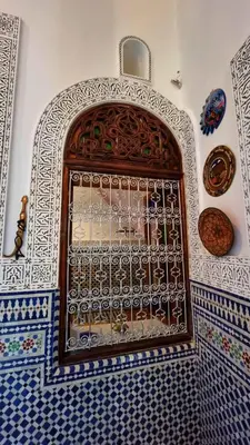 a wall with a window in a room with blue and white tiles at Dar La Bague de Kenza in Fès