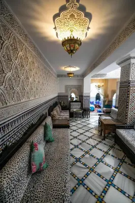a large living room with a chandelier and a couch at Riad Mounana fez 13th century luxury palace& spa in Fès