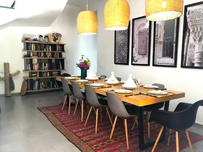 a dining room with a long wooden table and chairs at Palais Akki in Marrakech