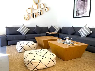 a living room with a blue couch and tables at Palais Akki in Marrakech