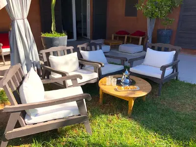 a group of chairs and a table in the grass at Palais Akki in Marrakech