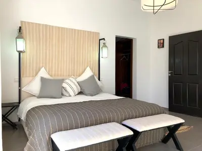 a bedroom with a large bed with two benches at Palais Akki in Marrakech