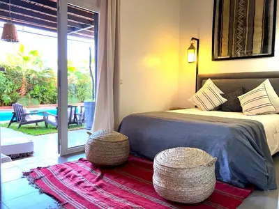 a bedroom with a bed and two tables and a patio at Palais Akki in Marrakech