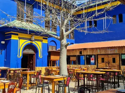a group of tables and chairs in front of a building at Hotel Batha in Fès