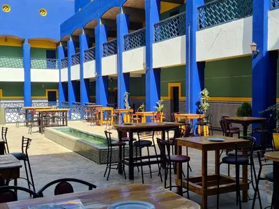 an empty patio with tables and chairs in a building at Hotel Batha in Fès