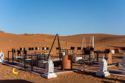 a group of tables and chairs in the desert at Moonlight Luxury Camp in Merzouga