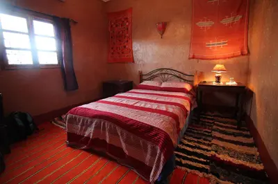 a small bedroom with a bed and a window at Kasbah Valentine in Aït Ben Haddou