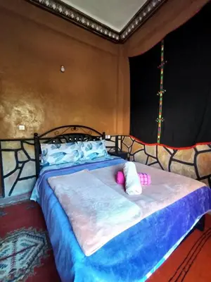 a bedroom with a bed with pink pillows on it at auberge restaurant tizgui in Tinerhir
