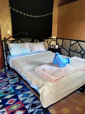 a bed with a teddy bear sitting on top of it at auberge restaurant tizgui in Tinerhir