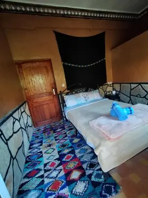 a bedroom with a bed with a teddy bear on it at auberge restaurant tizgui in Tinerhir