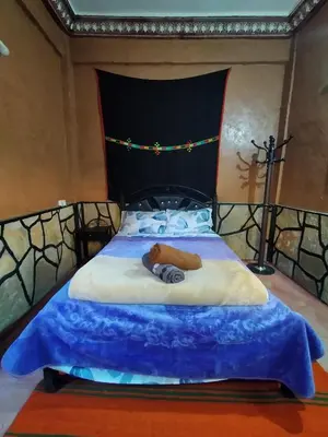 a large bed with a blue comforter on it at auberge restaurant tizgui in Tinerhir